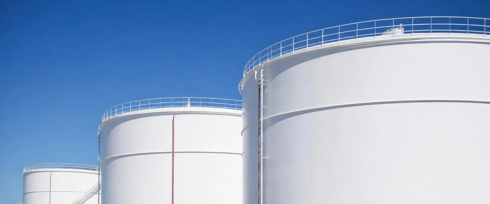 Tanques industriais de armazenamento de petróleo sob céu azul